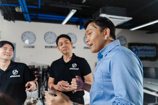 Offshored colleagues talking in the Manila office